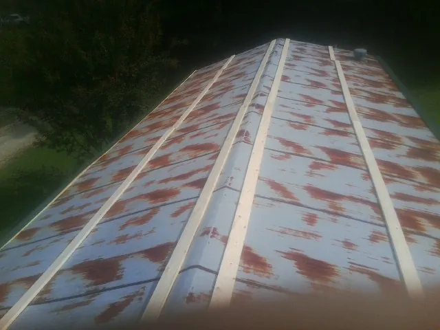 Rusted metal roof panels with new wood purlins before replacement — Storm Damage Roof Repair in West New York by Roofing Brothers