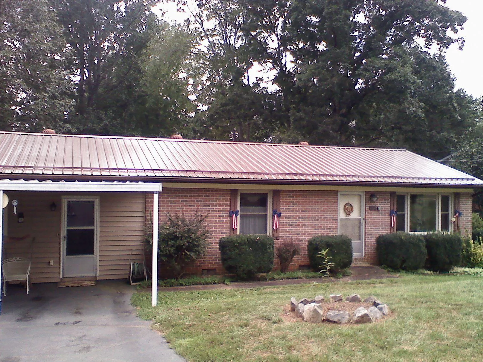Bronze metal roof and carport on a brick ranch home — Roof Repair work by our crew in West New York